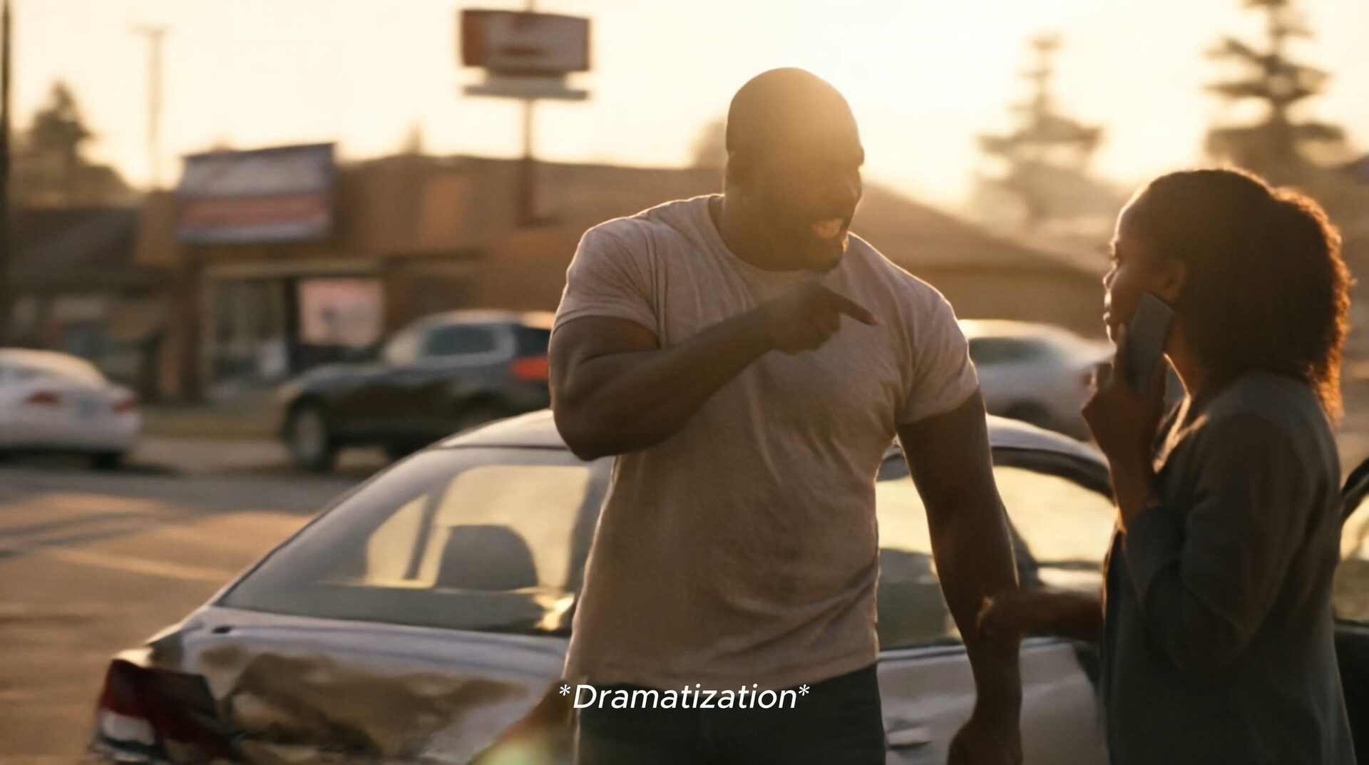 Dramatized frame from a personal injury firm concept film: two people at the scene of a car accident, labeled "Dramatization."